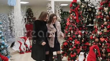 超市里的两个女人在圣诞节为你的家挑选圣诞装饰品。 女人看到圣诞节